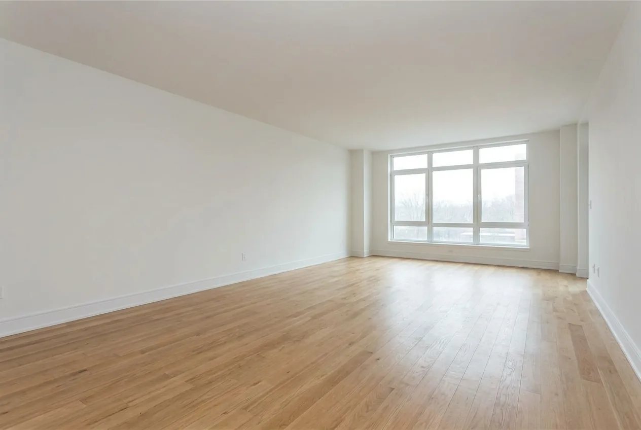 An empty living room with bare walls and no furniture, photographed for a listing