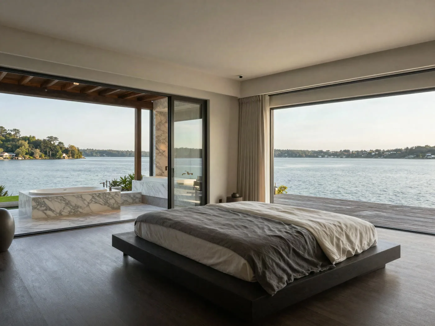 Primary suite with a glass wall opening to a private balcony over the water